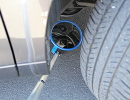 Telescopic portable inspection mirror in use checking under a vehicle
