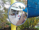 Outdoor convex mirror mounted on a pole overlooking a childcare playground