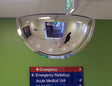 Indoor half dome safety mirror mounted for aisle visibility