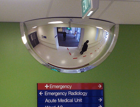 Indoor half dome safety mirror mounted for aisle visibility