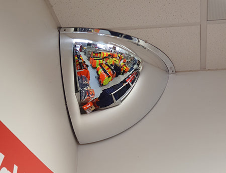 Indoor quarter dome safety mirror mounted in a corner