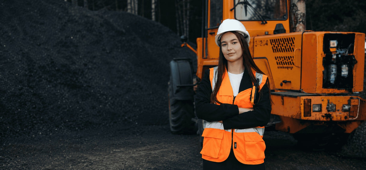 worker in high vis standing infront of a bull dozer
